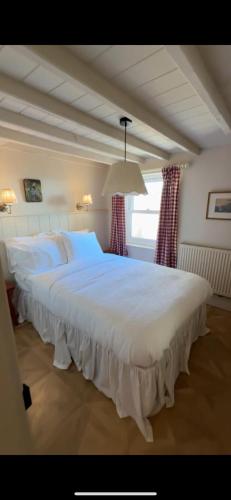 ein großes weißes Bett in einem Zimmer mit Fenster in der Unterkunft Sunray House - Sea View, 20m from the Beach in Felixstowe