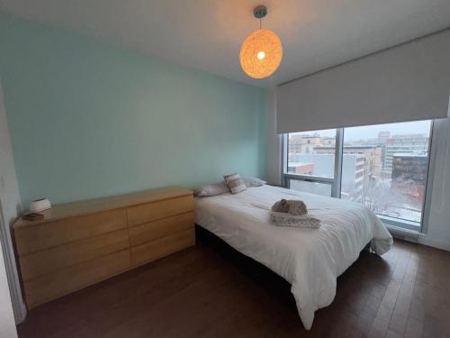een slaapkamer met een bed en een groot raam bij Cosy old port in Montreal