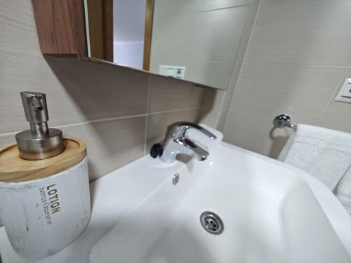 a bathroom sink with a faucet and a mirror at Doña Urraca in Porriño