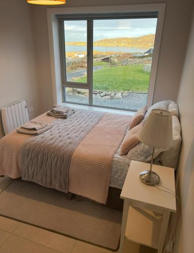 a bedroom with a bed and a large window at Mary’s Seaview Clifden in Errislannan