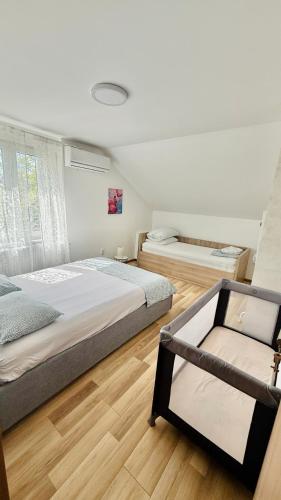 two beds in a room with wooden floors at Casa Bella Fruška Gora with HOT TUB in Velika Remeta