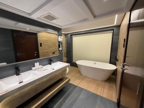 ein Badezimmer mit zwei Waschbecken und einer Badewanne in der Unterkunft Quiet Dreams - Serviced Apartments King abdul Aziz Street Branch in Dschidda