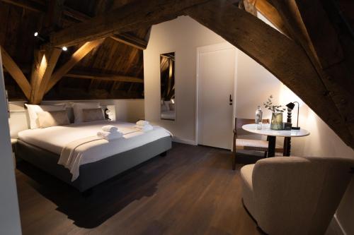 a bedroom with a bed and a table and a chair at Boutique hotel the Grand in Nijmegen