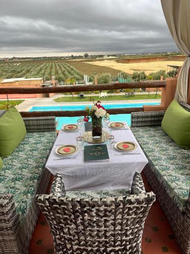 a table with a white table cloth and flowers on it at Ferme Tynass - Amazigh Room Fes in Douar er Rouazi