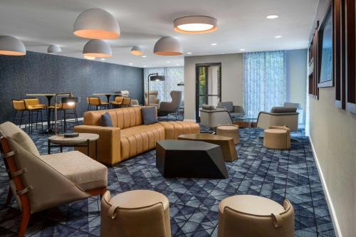 a hotel lobby with couches and chairs and tables at Courtyard by Marriott Frederick in Frederick