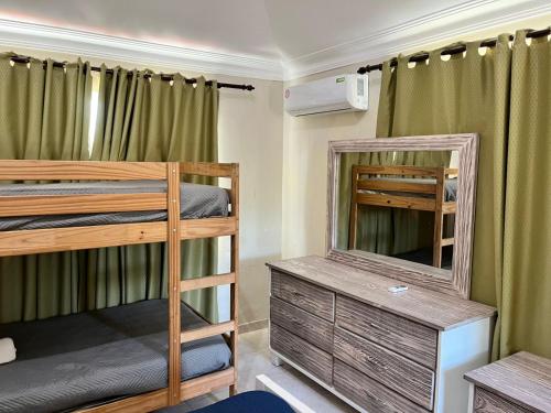 een kamer met 2 stapelbedden en een spiegel bij Bavaro Hostel in Punta Cana