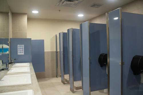 a row of blue stalls in a public restroom at Travohostal Monterrey Historico in Monterrey