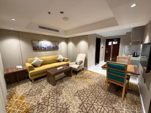 ein Wohnzimmer mit einem gelben Sofa und einer Küche in der Unterkunft Quiet Dreams - Serviced Apartments King abdul Aziz Street Branch in Dschidda