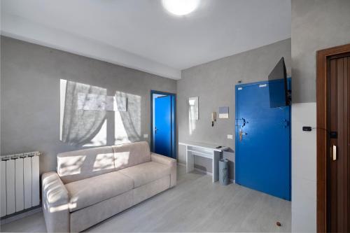 a living room with a couch and a blue door at Sweetie Tuscany House in Montecatini Terme
