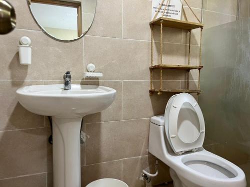 un bagno con un water, un lavandino e uno specchio di Corales Punta Cana a Punta Cana