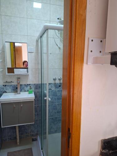 a bathroom with a shower and a person in a mirror at Hosting Altos da cidade perto de tudo in Bauru