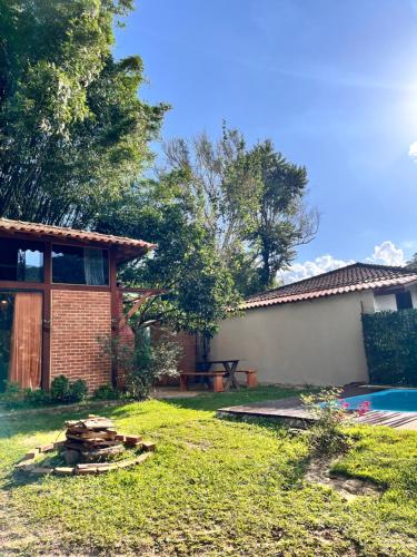 a backyard with a house and a pool at Chalé Cabana Lumiar in Nova Friburgo