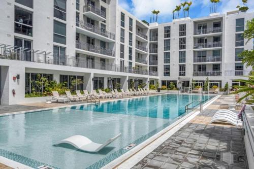 una grande piscina con sedie a sdraio di fronte a un edificio di Miami Skyline Residences by Untitled Stay a Miami
