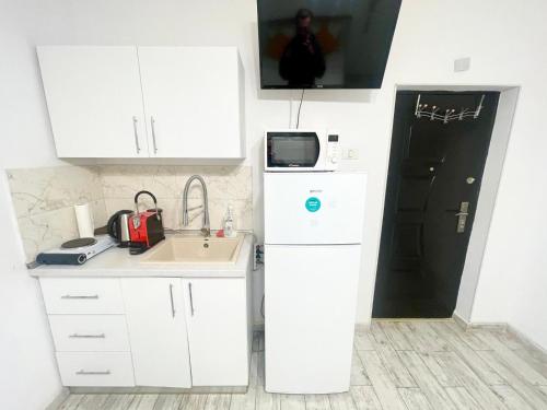 Old Town House في بوخارست: مطبخ صغير بخزائن بيضاء ومغسلة