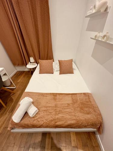 Un dormitorio pequeño con una cama con dos almohadas. en Le Cosy Grange Blanche - 2 chambres, en Lyon