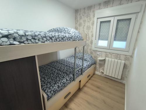 a small bedroom with two bunk beds and a window at Los Cala-Vivienda tranquila en casa unifamiliar in Vigo