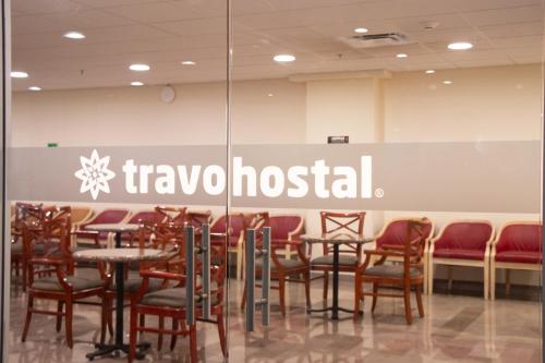 a restaurant with chairs and tables and a sign that reads travelghost at Travohostal Monterrey Historico in Monterrey