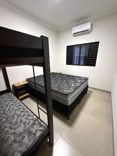 a bedroom with two bunk beds and a window at Recanto Neri & Neide in Olímpia