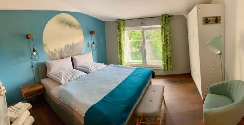 a bedroom with a bed and a chair and a window at Ferienwohnungen Zur Biberburg in Friedrichswalde