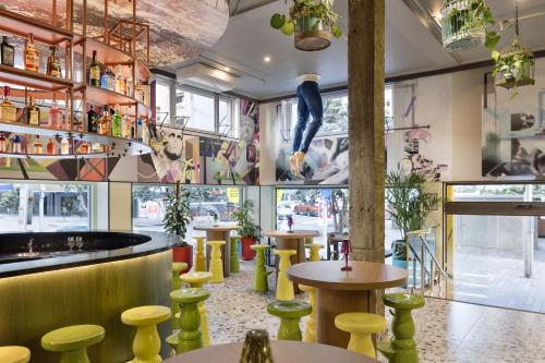 オークランドにあるJO&JOE Aucklandの黄色い椅子とバーのあるレストラン