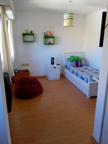 Alejandro في مار ديل بلاتا: غرفة نوم مع سرير وأرضية خشبية