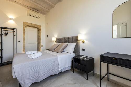 a bedroom with two beds and a mirror at Dione Ortigia in Siracusa