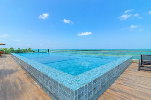 uma piscina com o oceano ao fundo em Nossa Praia Flats - Açores 109 Piscina Vista Panorâmica em Tamandaré
