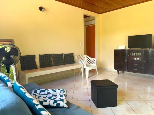 ein Wohnzimmer mit Sofa und Fernseher in der Unterkunft Villa Libel'ulle in Le Robert