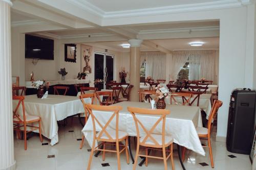a restaurant with tables and chairs with white table cloth at Sasselo Hotel in Accra