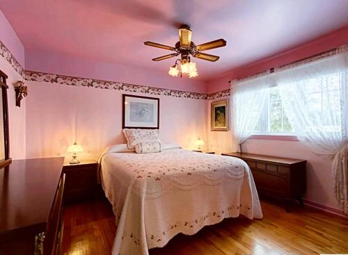 a bedroom with a bed and a ceiling fan at 2beds in Room A Free parking 15min to downtown in Longueuil