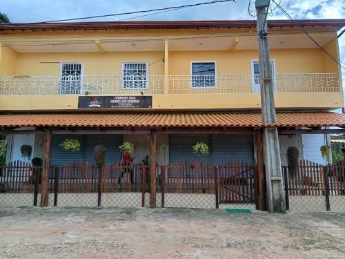 una casa gialla con una recinzione davanti di Maria do Bairro a Guaraciaba do Norte