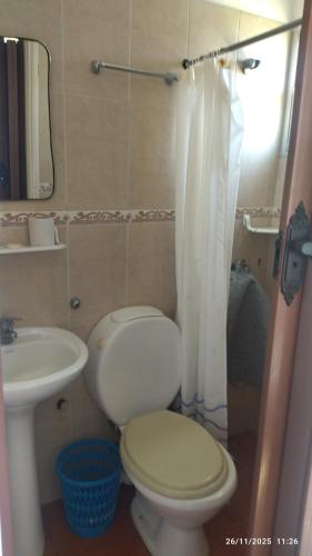 a small bathroom with a toilet and a sink at Hospedaje La Tuna in Rocha
