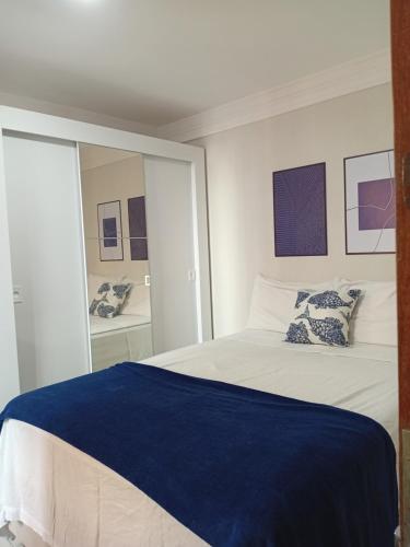 una camera da letto con un letto grande con una coperta blu di Apartamento na praia de Manaíra João Pessoa PB a João Pessoa