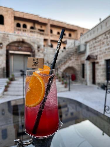 a drink sitting on a table with an orange slice at ŞAHMERAN OTEL & Cafe in Midyat