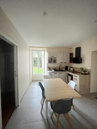 eine Küche mit einem Holztisch und einigen Stühlen in der Unterkunft Meublé Voltour dans la Villa Denise in Vals-les-Bains