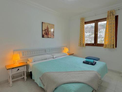 een slaapkamer met een bed, een tafel en een raam bij Puerto Rico Sea & Sun in Puerto Rico de Gran Canaria