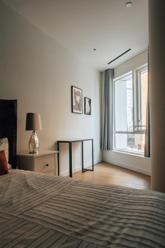 a bedroom with a bed and a large window at LUXURY 3 Bed 3 Bath Apartment in Central London in London