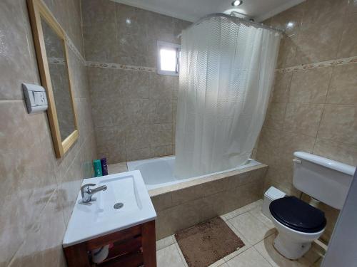 a bathroom with a sink and a toilet and a tub at Nomade bedbox Hostel in El Chalten