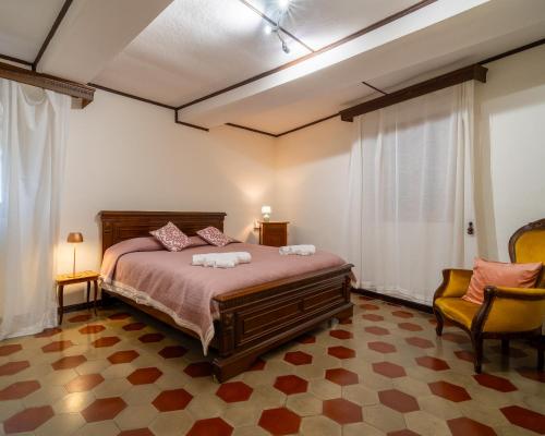 a bedroom with a bed and two chairs in it at I Cuculi vacation home in Lucca in Lucca