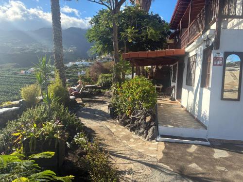 a woman sitting on a bench in front of a building at El Sueño Del Angel in Santa Cruz de la Palma