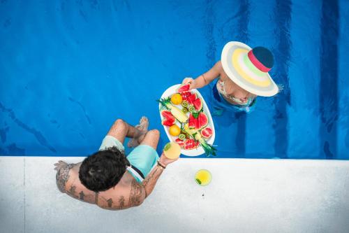 Un hombre en una piscina sosteniendo un ramo de flores. en NEW!The HideawayPoolPickleballPutt-PuttKayaks!, en Marathon