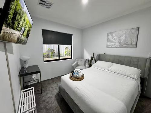 a bedroom with a large white bed and a chair at Modern & Chilled Stay in Bayswater in Perth