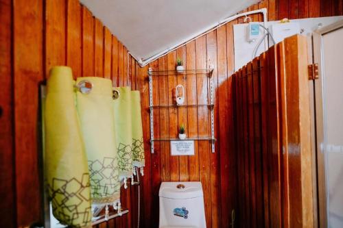 a bathroom with a toilet and wooden walls at Classic, Cozy House for Transient in Baguio City 1 in Baguio