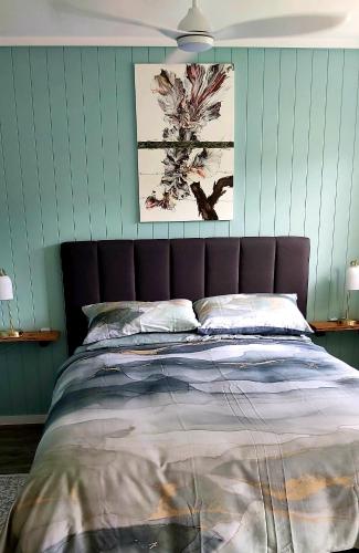 a bed in a bedroom with green walls at Darwin Cottage in Kerikeri