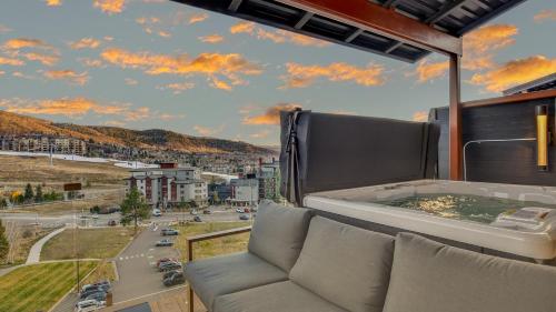 a balcony with a couch and a view of a city at Crescendo Crest in Steamboat Springs