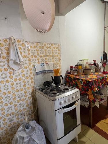 a kitchen with a white stove and a table at Quarto aconchegante no centro in São Luís