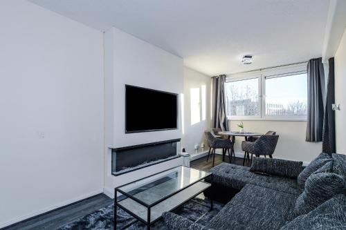 a living room with a couch and a tv at 1BR Apartment By Kammili Properties - Near City Centre, Universities & Hospital in Manchester