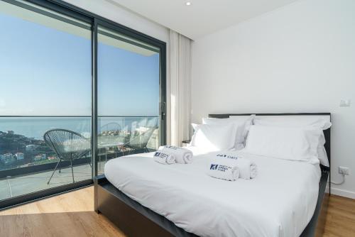 a bedroom with a large bed and a large window at Villa Fenix II by Madeira Dream Stays in Câmara de Lobos