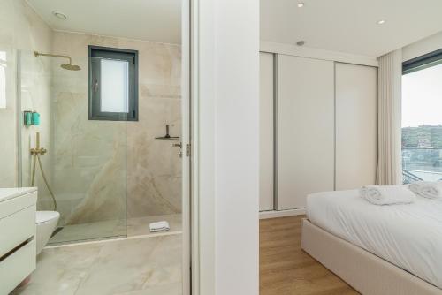 a bathroom with a shower and a bed with a glass door at Villa Fenix II by Madeira Dream Stays in Câmara de Lobos