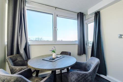 a room with a table and chairs and a window at 1BR Apartment By Kammili Properties - Near City Centre, Universities & Hospital in Manchester